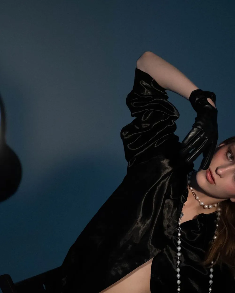 Maison Noir model in a satin black blouse and leather gloves, studio editorial